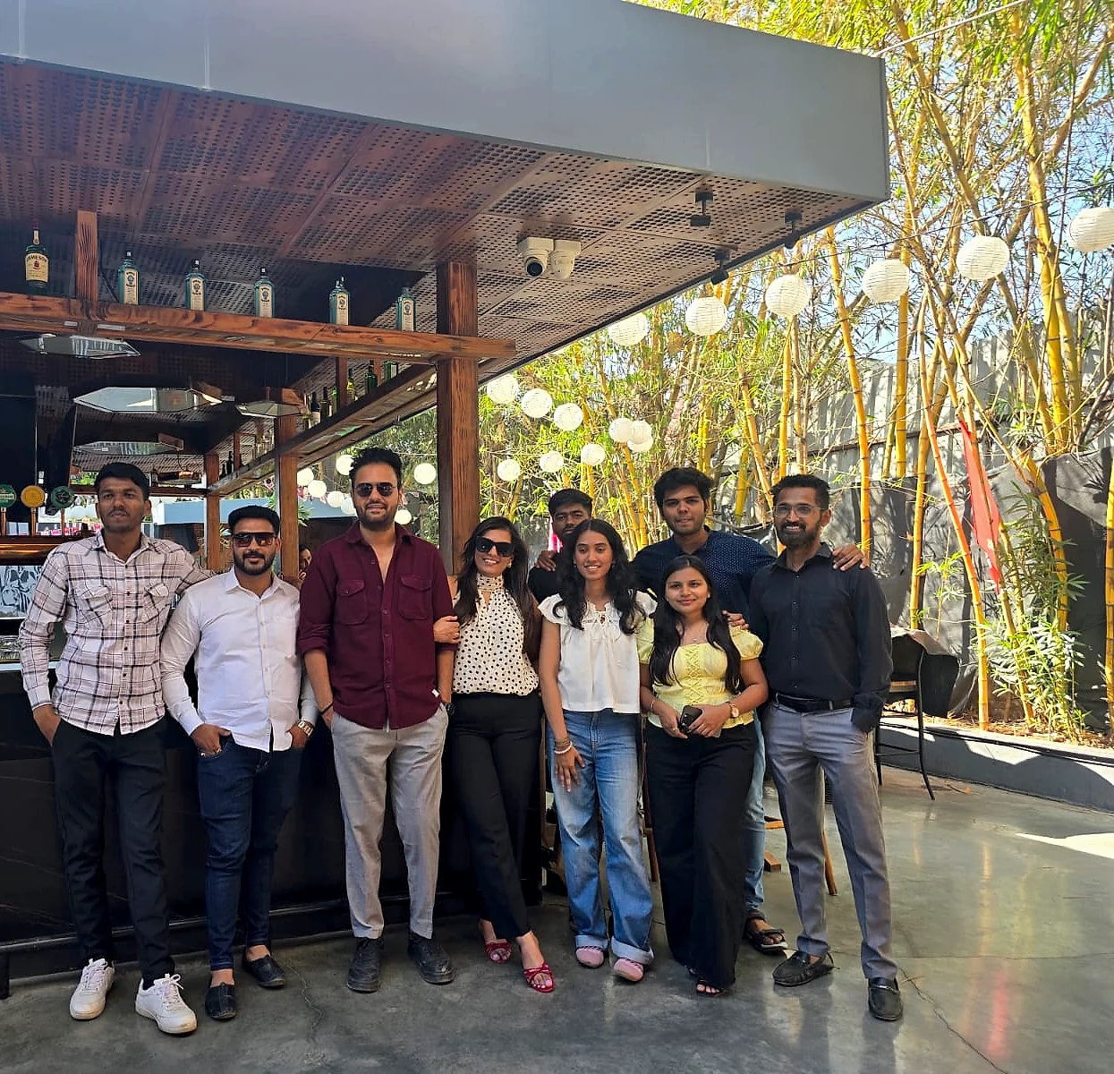 The RDA team standing together in sunlight beside bamboo and lanterns
