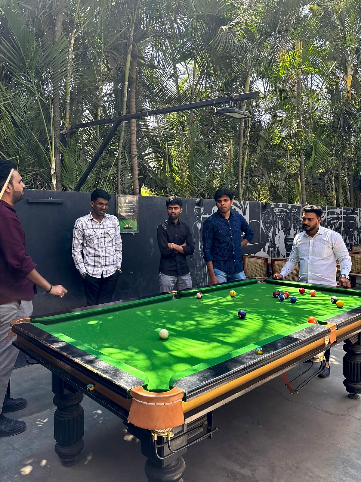 RDA team members around a pool table, one lining up a shot